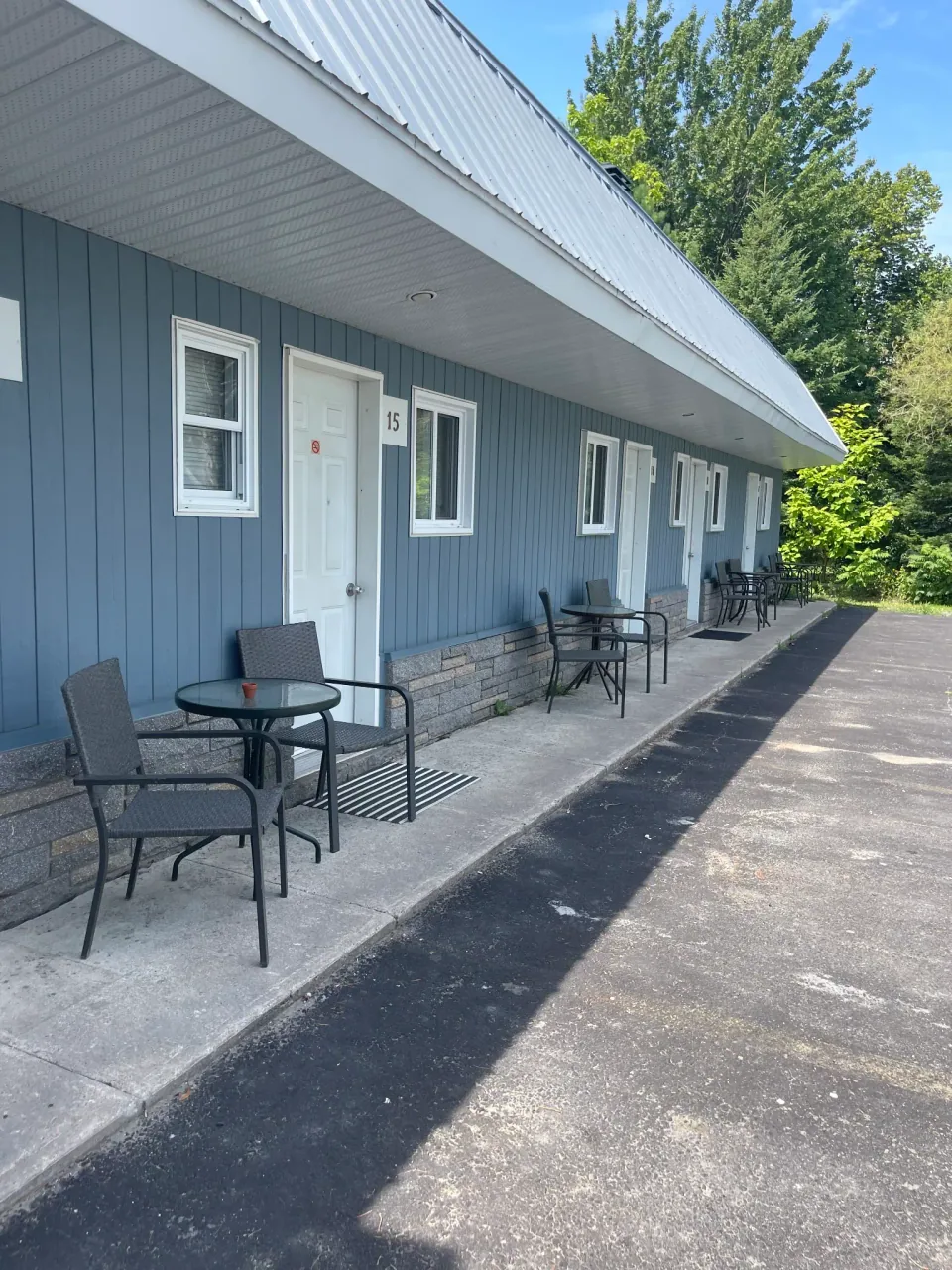 Rangée de chambres bleues avec terrasses individuelles au Motel Saint-Ours.